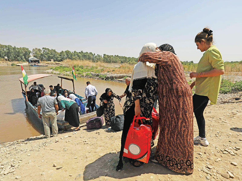 عراقيون يعبرون نهر دجلة من كردستان العراق لقضاء عطلة عيد الأضحى مع ذويهم بسورية أمس الأول t(أ ف ب)