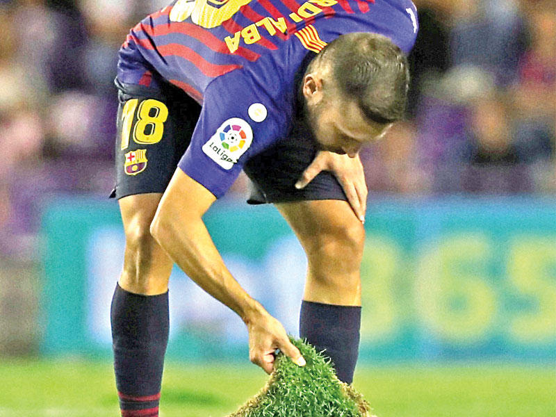 جوردي البا لاعب برشلونة يحاول إصلاح أرضية الملعب