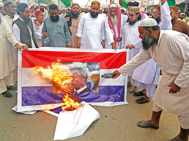 باكستانيون غاضبون يحرقون صورة لفيلدرز في كراتشي أمس (اي بي اي)
