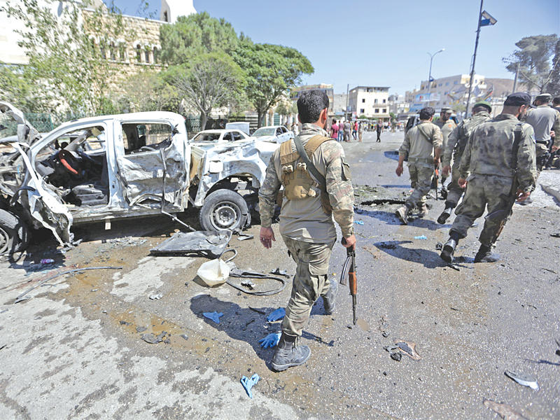 عناصر الجيش الحر في موقع انفجار سيارة مفخخة في أعزاز أمس (رويترز)