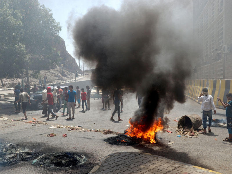 محتجون يغلقون طريقا قرب البنك الأهلي في عدن أمس (رويترز)