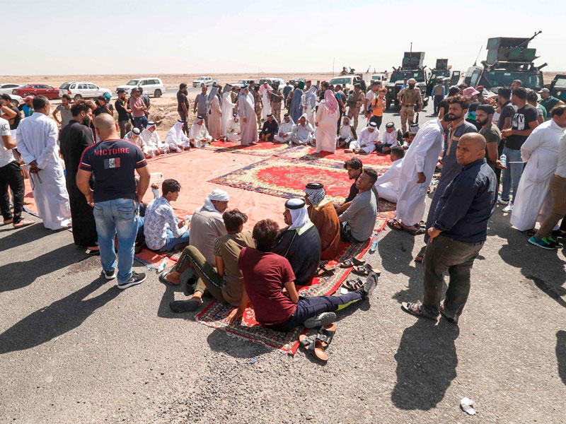 الأمن يحاصر عراقيين أغلقوا معبر إيران بالبصرة أمس (أ ف ب)