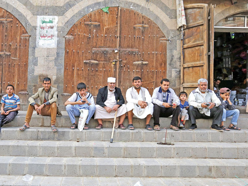 يمنيون أمام متاجر مغلقة بأحد أسواق صنعاء أمس الأولt(إي بي أيه) 