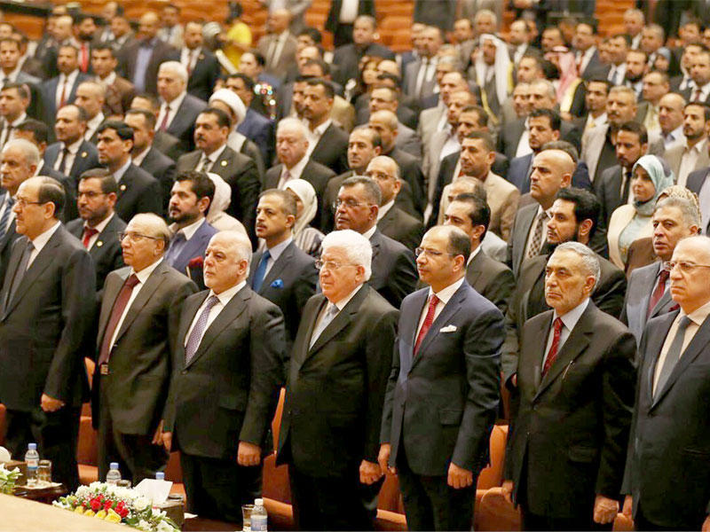 العبادي ومعصوم والجبوري خلال عزف السلام الوطني بأولى جلسات البرلمان الجديد في بغداد أمس (إي بي أيه)