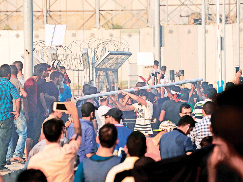 فلسطينيون يتظاهرون على معبر إيريز أمس (أ ف ب)