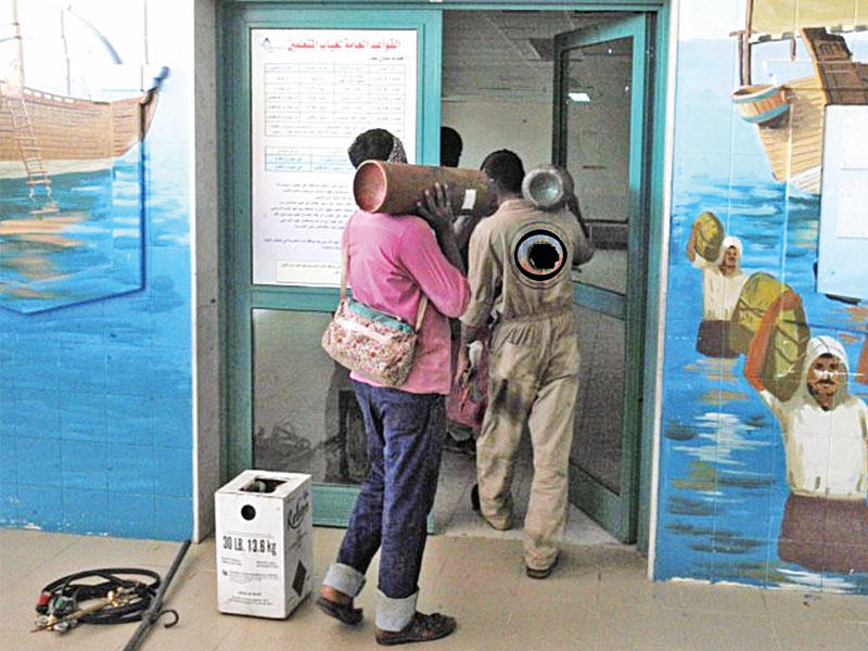 عمال يباشرون صيانة أجهزة التكييف في إحدى المدارس