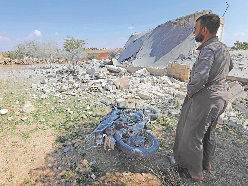 سوري قرب منزل دمرته غارات على قرية المنطار جنوب إدلب أمس (أ ف ب)