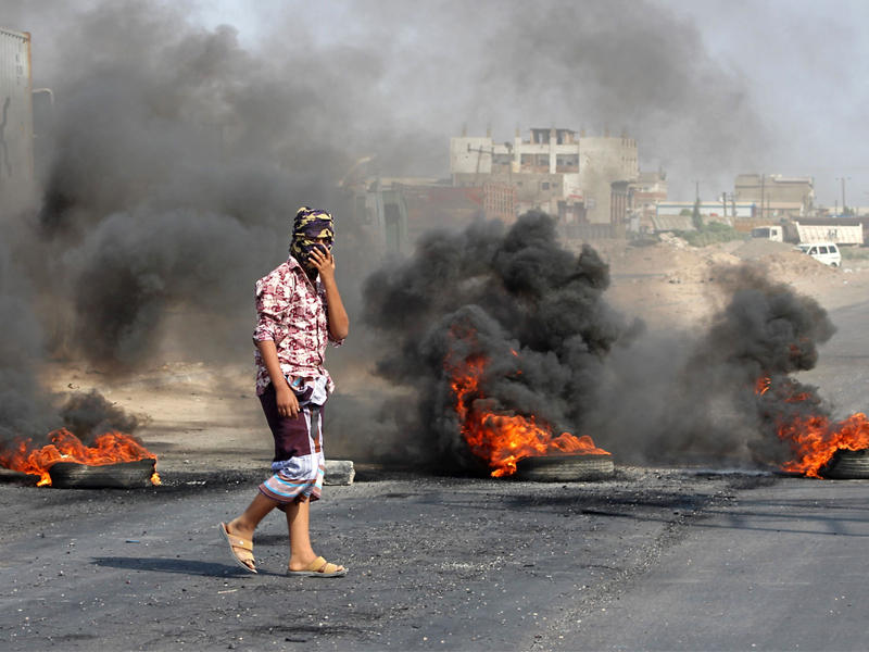 إشعال الإطارات في احتجاجات على الغلاء بعدن أمس (أ ف ب)