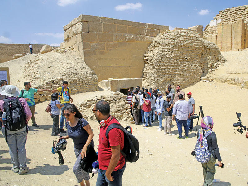 سائحون خارج مقبرة «موحا» الفرعونية التي أعيد افتتاحها أمس الأول بعد عقود من الإغلاق في الجيزة (إي بي أيه)