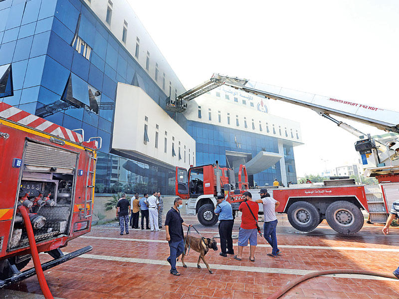 الإطفاء والإنقاذ أمام مقر شركة النفط في طرابلس أمس (أ ف ب)