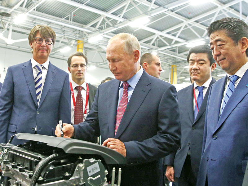 بوتين يوقع على محرك سيارة مازدا مصنَّع في روسيا أمس  (ا ف ب)