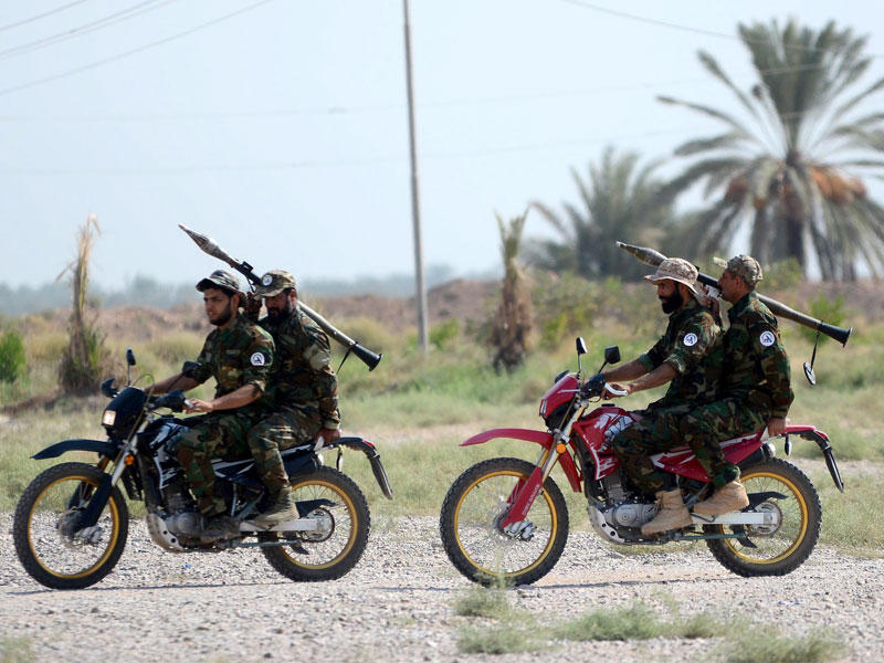 أفراد من الحشد على دراجات نارية خلال تدريب في قاعدة عسكرية بمدينة بلد شمال بغداد أمس (إي بي إيه)