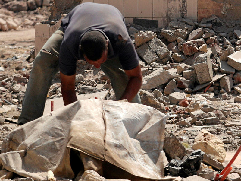 عامل يشارك في هدم حي عشوائي خلف مثلث ماسبيرو بالقاهرة أمس الأول (رويترز)