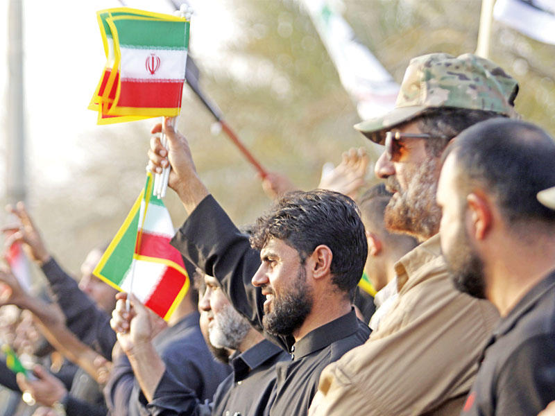 عراقيون يلوحون بأعلام إيرانية خلال تظاهرة أمس الأول في البصرة احتجاجاً على إحراق القنصلية الإيرانية في المدينة (أ ف ب)