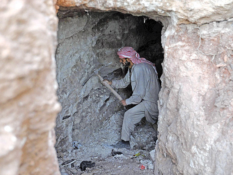 سوري يحفر كهفا في بلدة كفرعين جنوب إدلب تحسباً لأي هجوم واسع على المحافظةt (أ ف ب)