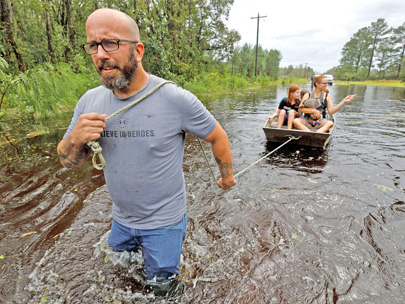 متطوع أميركي يسحب قارباً على متنه نساء وأطفال في نورث كارولينا    (رويترز) 
