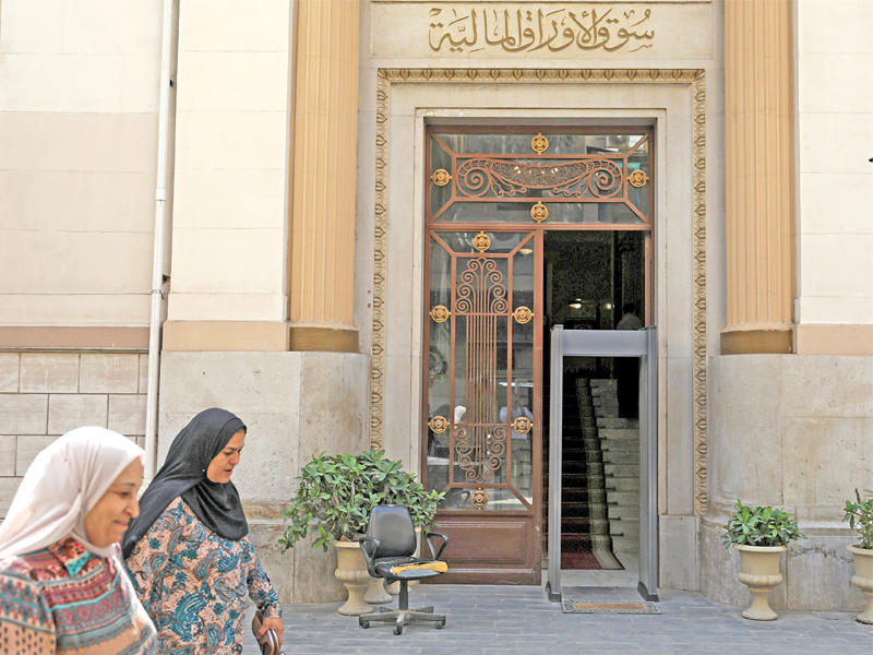 مصريتان تمران أمام مبنى البورصة في القاهرة أمس الأول    (رويترز)