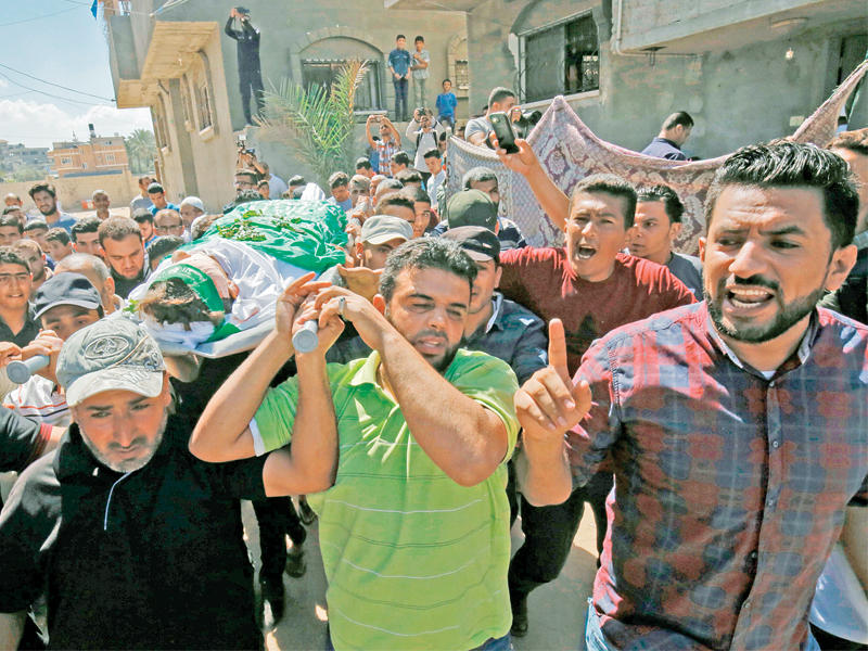 فلسطينيون يشيعون جثمان صبي قتلته إسرائيل عند سياج غزة أمس الأول (أ ف ب)