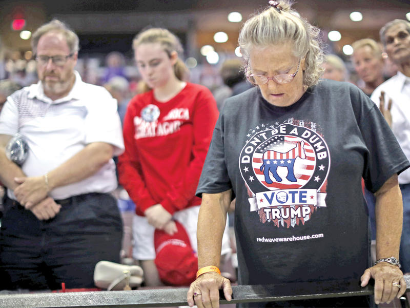مناصرون لترامب يتلون صلاوات خلال تجمع حضره الرئيس في ميزوريt (رويترز)