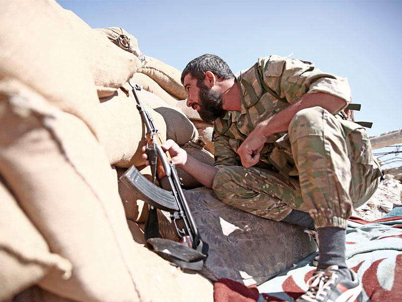 مقاتل في حركة «نور الدين الزنكي» خلف ساتر على جبهة حلب أمس الأول (أ ف ب)