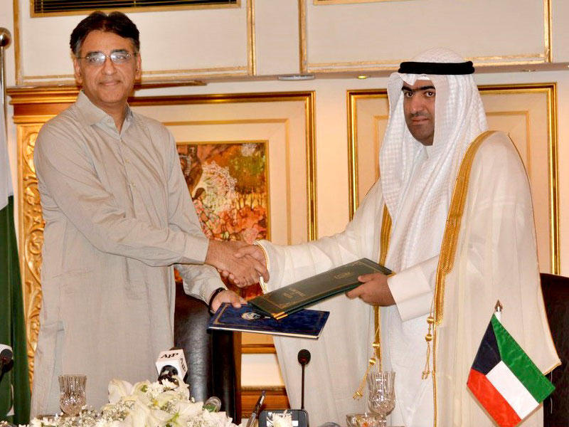 وزير التجارة والصناعة الكويتي خالد الروضان ووزير المالية الباكستاني اسد عمر خلال توقيع محضر الاجتماع