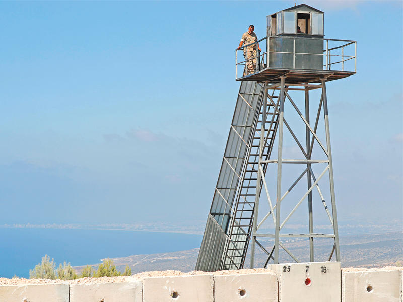 برج مراقبة لبناني قرب الجدار الذي تبنيه إسرائيل على الحدود في صورة تعود لبداية الشهر الجاري (أ ف ب)