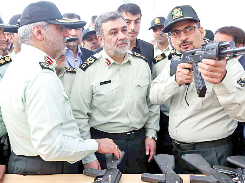 قائد قوة الشرطة الإيرانية حسين أشتاري يستعرض أسلحة خلال معرض للأمن في مدينة المصلي أمس (إرنا)