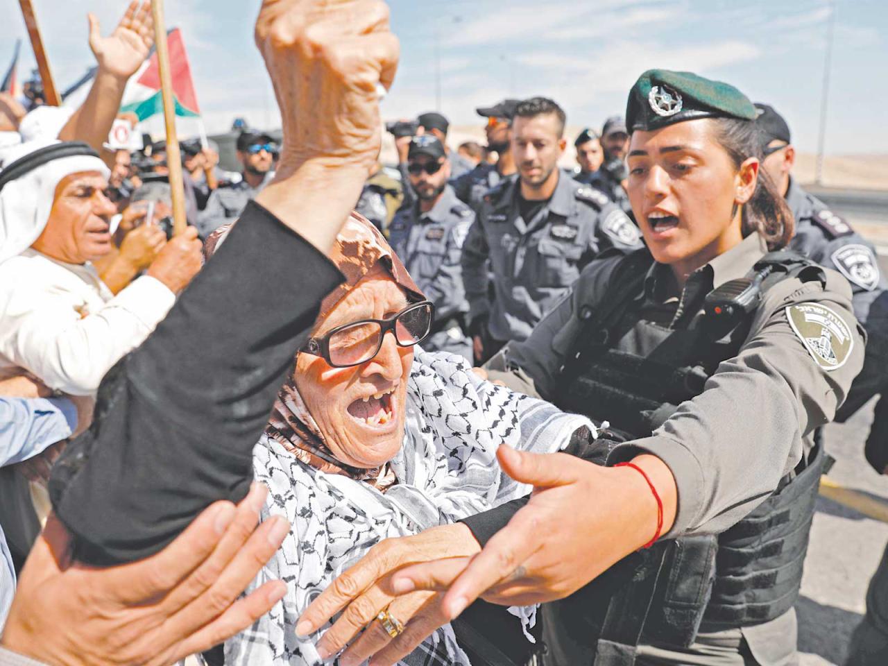 مسنة فلسطينية تتحدى أمن إسرائيل على طريق قرية خان الأحمر (أ ف ب)