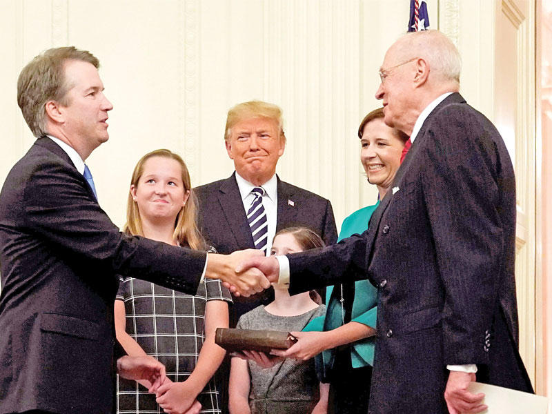 ترامب متوسطاً كافانو وعائلته في البيت الأبيض أمس الأول     (رويترز)