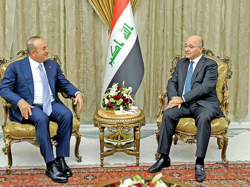 الرئيس العراقي برهم صالح مستقبلا وزير خارجية تركيا مولود جاويش أوغلو أمس ببغداد (رويترز)