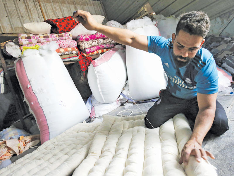 منجد عراقي يعمل في ورشته في مدينة الصدر ببغداد أمس (أ ف ب)n