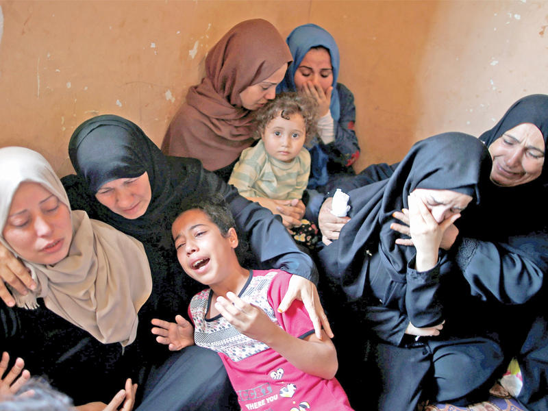 قريبات الشاب المقتول محمد عباس أمس الأول على يد الإسرائيليين في غزة ينتحبن أمس قبل دفنه      (رويترز)