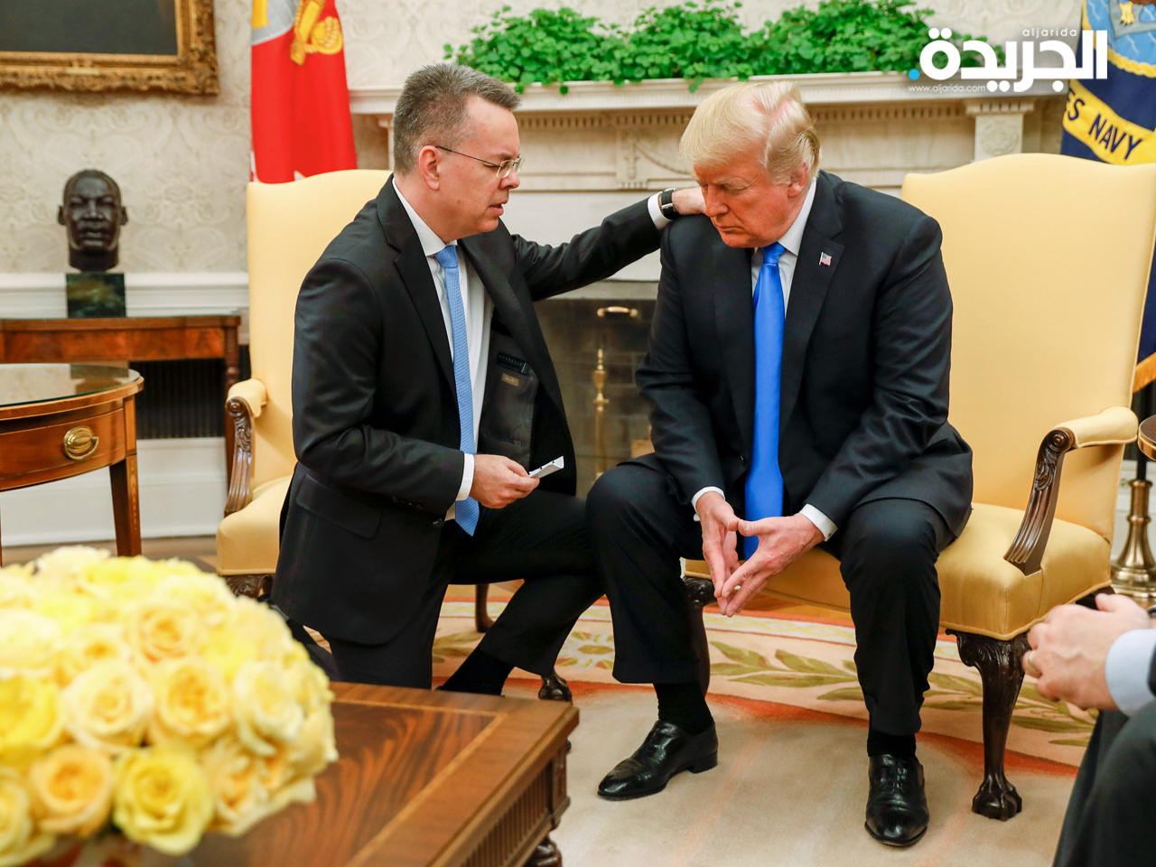 برانسون يتلو صلوات راكعاً ويده على كتف ترامب بالمكتب البيضاوي أمس الأول (أ ف ب)