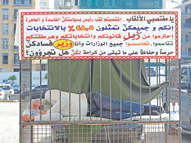 ناشط لبناني ينام أمس داخل قفص في وسط بيروت احتجاجاً على أداء الطبقة السياسية (أ ف ب)