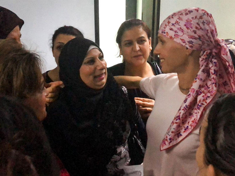 أسماء زوجة الرئيس السوري، المصابة بسرطان الثدي، خلال لقائها نساء يخضعن لاختبار كشف هذا المرض بالمستشفى العسكري في دمشق أمس 