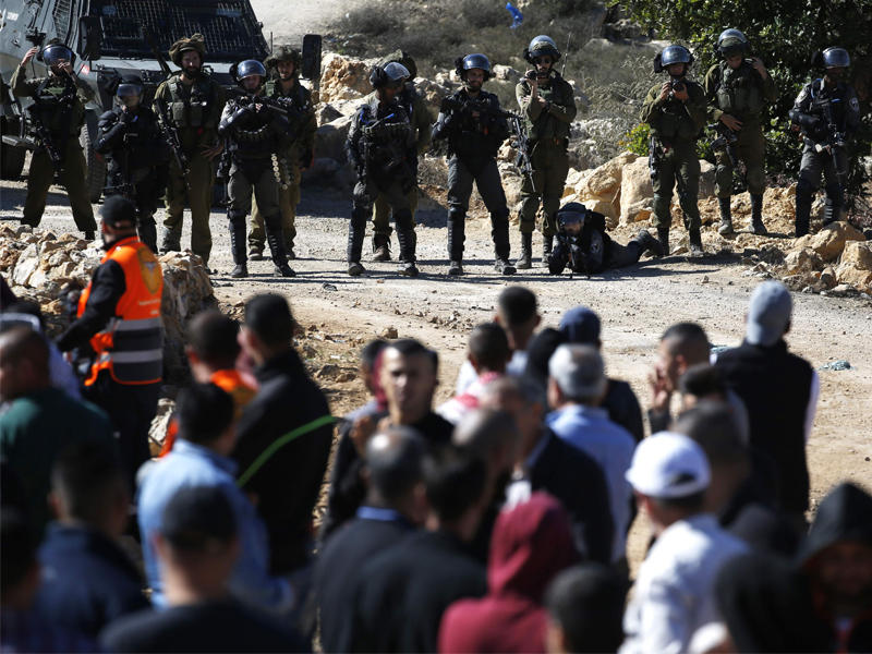 فلسطينيون يواجهون جنوداً إسرائيليين في المزرعة الغربية قرب رام الله أمس (أ ف ب)