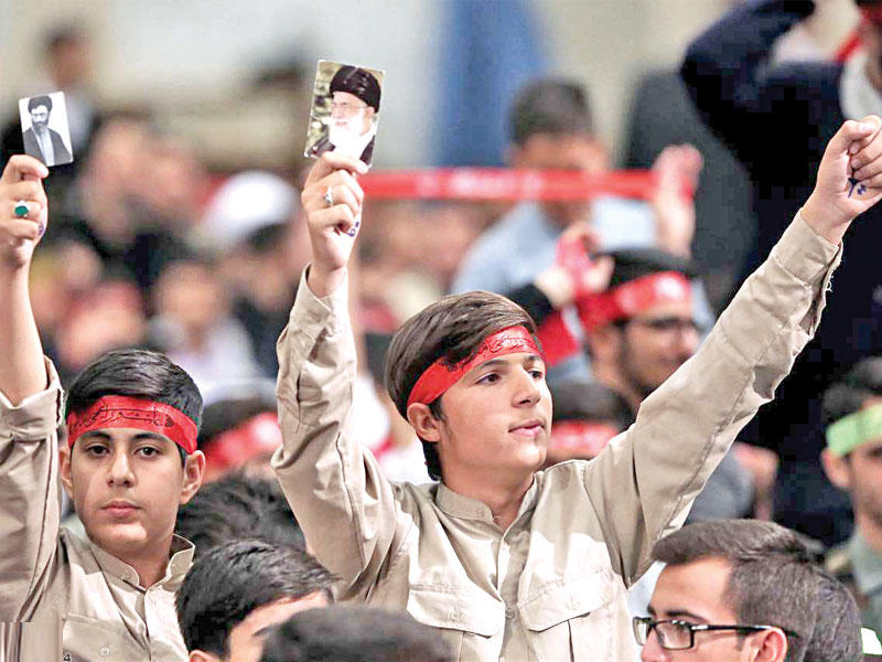 تلميذان إيرانيان يرفعان صورة للخميني وأخرى لخامنئي خلال لقاء مع المرشد الأعلى في طهران أمس (ارنا)