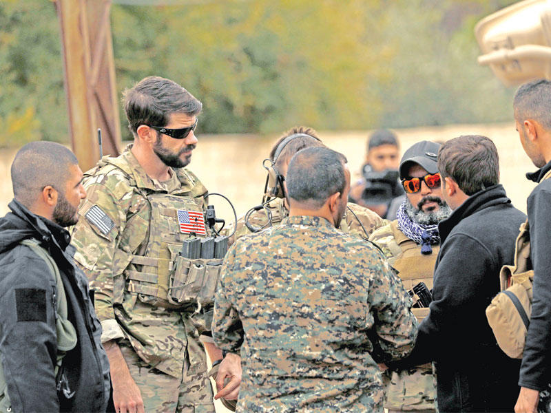 مقاتلون من «قسد» مع جنود أميركيين على الحدود التركية - السورية أمس الأول    (أ ف ب)