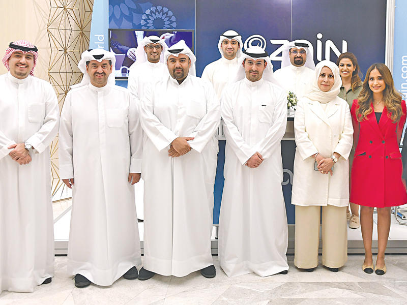 الروضان تتوسط الغربللي وفريق «زين» في جناح الشركة