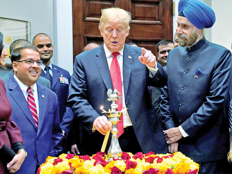 ترامب محتفلاً في البيت الأبيض بعيد ديوالي الهندوسي برفقة السفير الهندي أمس الأول               (رويترز)