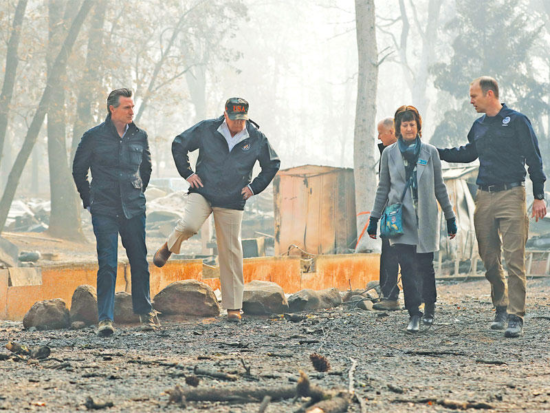 ترامب يتفقد منطقة تضررت من حريق كاليفورنيا أمس الأول (رويترز)