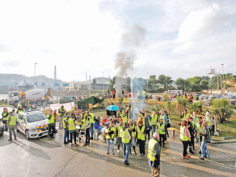 محتجّون من «السترات الصفراء» يغلقون مدخل شركة «توتال» الفرنسية في مدينة فو سور مير أمس      (رويترز)