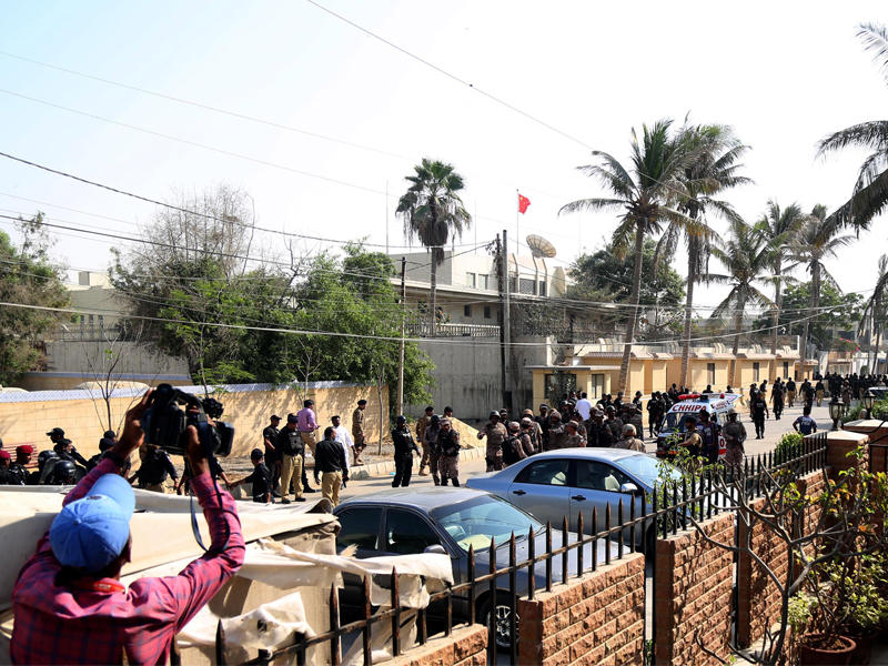 رجال أمن ومدنيون باكستانيون في موقع قريب من القنصلية الصينية بكراتشي أمس (إي بي أيه)