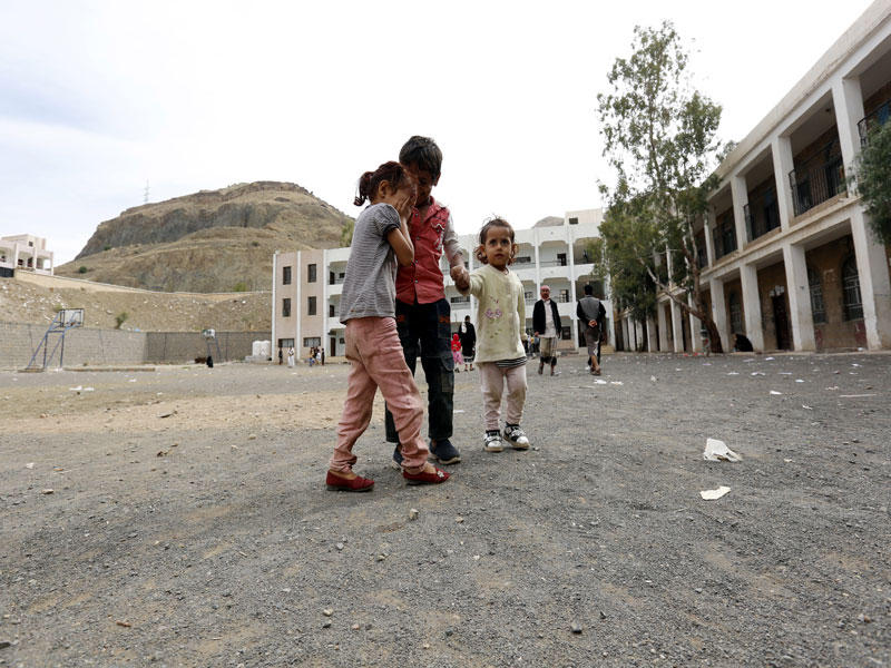 أطفال بانتظار تسجيل أسرتهم داخل مركز للنازحين من الحديدة في صنعاء (إي بي أيه)
