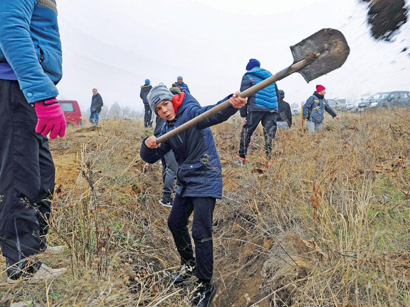 فتى أوكراني يحفر خندقاً على شاطئ بحر آزوف أمس (أ ف ب)