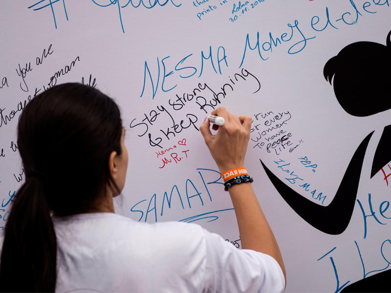 فتاة توقع على جدارية قبل انطلاق أول سباق للسيدات بالقاهرة أمس (اي بي آي)