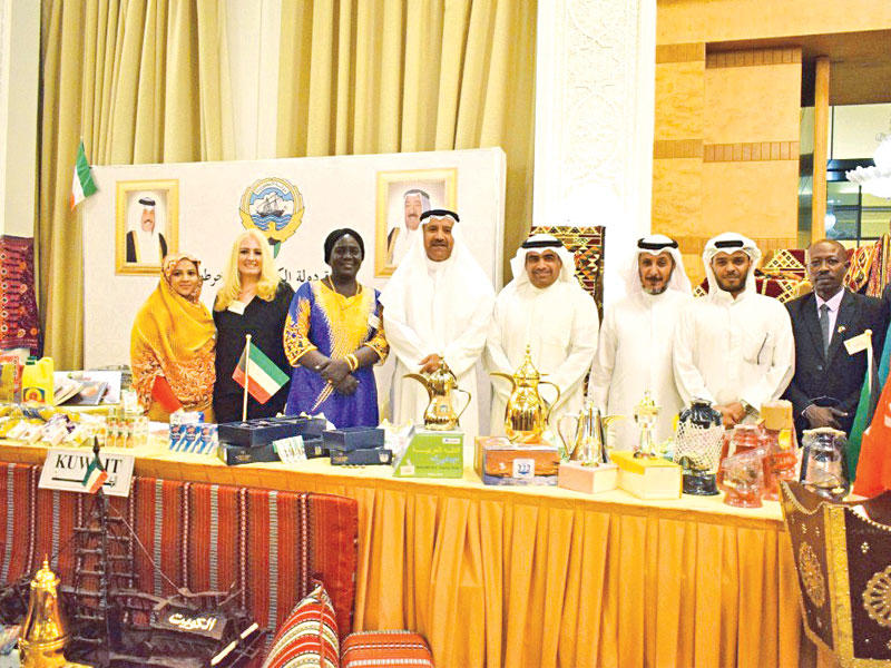 السفير الكويتي يتوسط العاملين في الجناح الكويتي