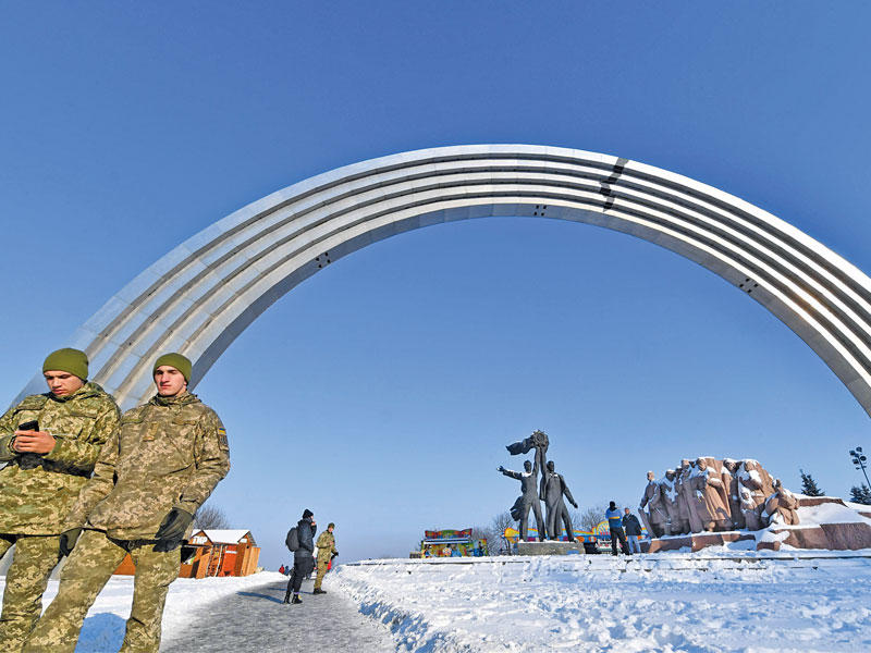 جنديان أوكرانيان قرب قوس نصر من الحقبة السوفياتية السابقة في كييف أمس (أ ف ب)