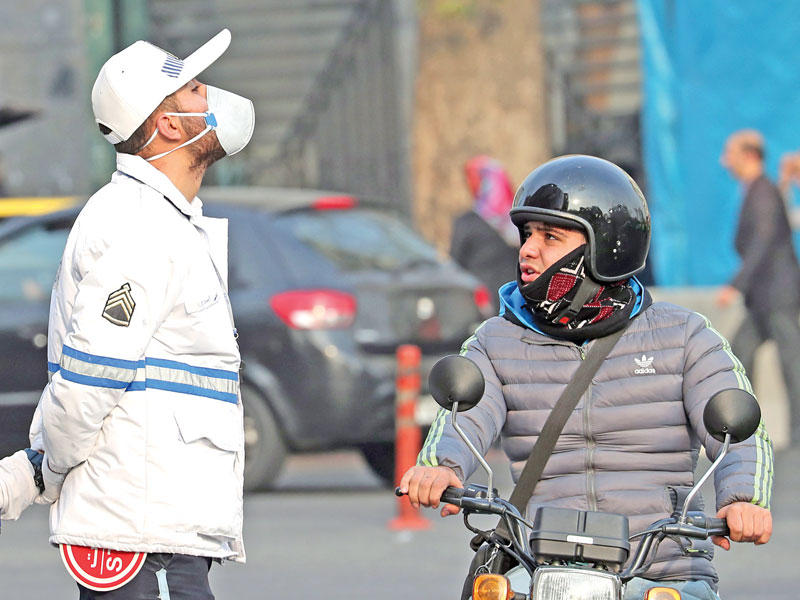 رجل مرور يضع قناعاً للوقاية من التلوث في طهران أمس (إي بي أيه)