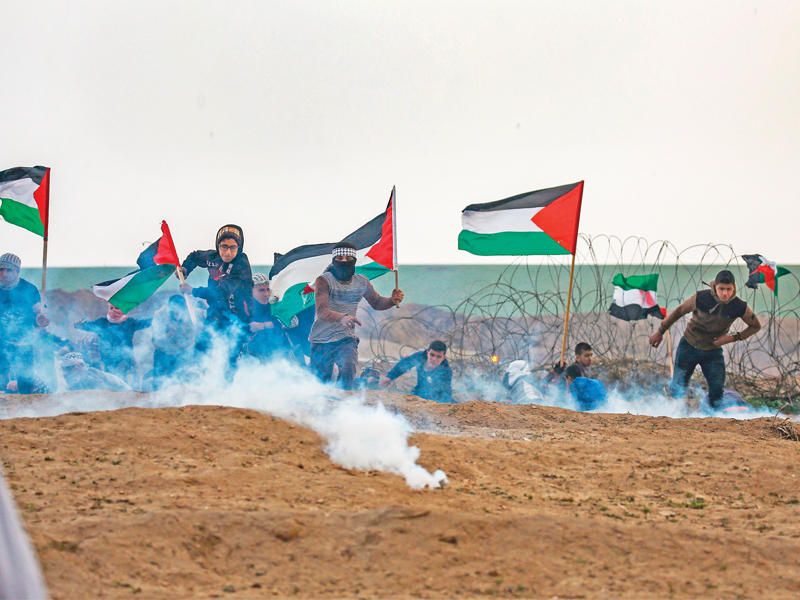 مواجهات بين مئات الفلسطينيين والجيش الإسرائيلي على أطراف غزة في إطار احتجاجات «مسيرات العودة» التي دخلت شهرها التاسع أمس بجمعة «انتفاضة الحجارة الكبرى». (أ ف ب)